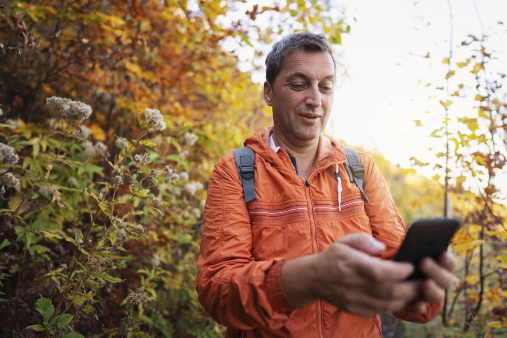 Mann på tur ser på mobilen